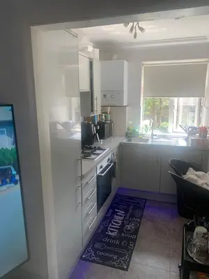 a kitchen with white cabinets and a stove top oven at Dmoney Ltd in Moffat