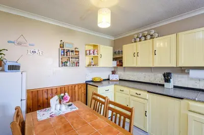 a kitchen with a table with chairs and a refrigerator at Guild Close in Moffat