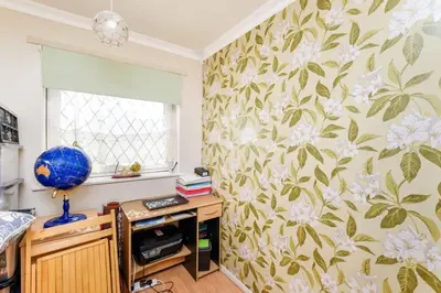 a room with a desk with a flowery wallpaper at Guild Close in Moffat