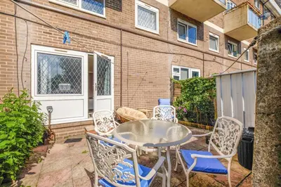a patio with a table and chairs in front of a building at Guild Close in Moffat