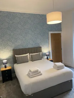 a bedroom with a large bed with two pillows on it at Spacious 2 bed sleeps 5 above traditional music pub in Paisley