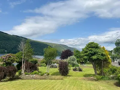 a park with a picnic table and a lake at Cairndow Stagecoach Inn in Cairndow