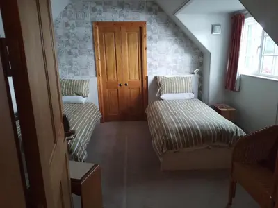 two beds in a small room with a window at Ardross Cottage in Aberfoyle