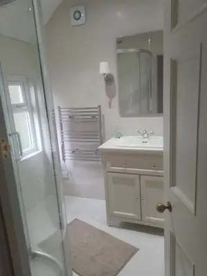 a white bathroom with a sink and a shower at Ardross Cottage in Aberfoyle