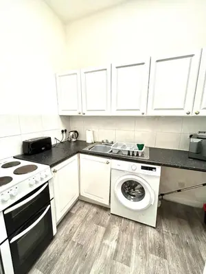 a kitchen with a washing machine and a sink at Flat 156 at M Rooms in Shotts Station