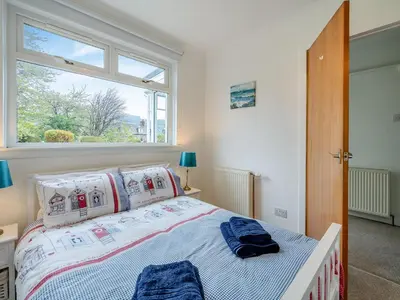 a bedroom with a bed and a large window at The Mulberry in Lamlash