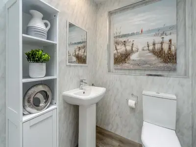 a white bathroom with a sink and a toilet at The Mulberry in Lamlash