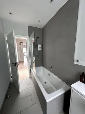 a bathroom with a tub and a shower in it at Kaimes Kip Stylish Edinburgh Five Bedroom Home in Edinburgh