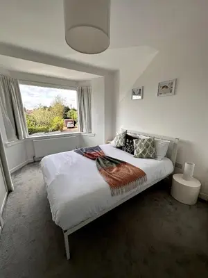a white bedroom with a large bed and a window at Kaimes Kip Stylish Edinburgh Five Bedroom Home in Edinburgh