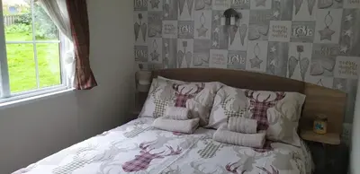 a bed with two pillows on it in a bedroom at Jasper Lodge in Beautiful Glendevon Country Park Perthshire Scotland in Glendevon