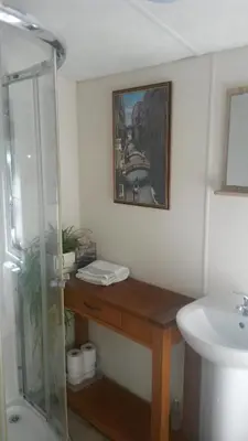a bathroom with a shower and a wooden counter with a sink at Jasper Lodge in Beautiful Glendevon Country Park Perthshire Scotland in Glendevon