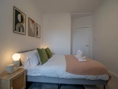 a bedroom with a bed with white sheets and green pillows at Pass the Keys Stay in Glasgow South in Glasgow