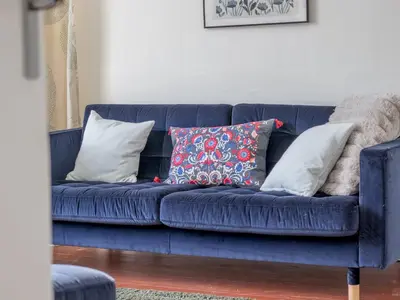 a blue couch with pillows on it in a living room at Pass the Keys Victoria Road Queens Park View in Glasgow
