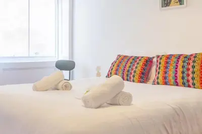 a bed with two stuffed animals on top of it at Pass the Keys Victoria Road Queens Park View in Glasgow