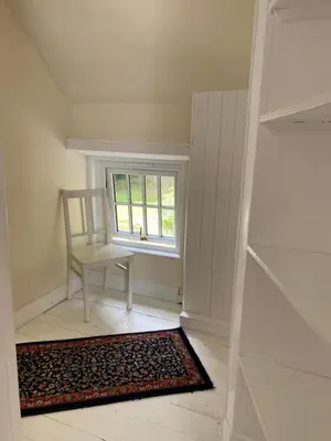 a empty room with a chair and a window at Birch Tree Cottage in Killichonan