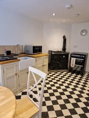 a kitchen with a black and white checkered floor at Birch Tree Cottage in Killichonan