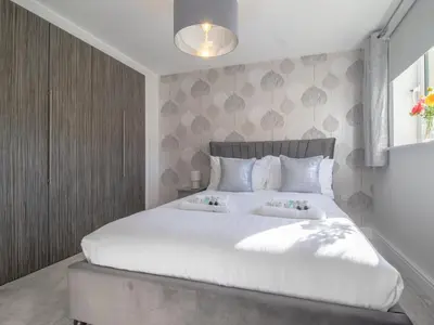 a bedroom with a large white bed with two pillows at Pass the Keys Next to Braehead - Free Parking in Renfrew