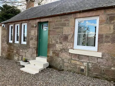a brick building with a green door and stairs at Wee Lyon Cottage Maybole 2 Bedroom Sleeps 4 in Maybole