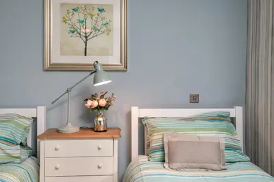a bedroom with a bed and a dresser with a lamp at Haymarket Apartments in Edinburgh