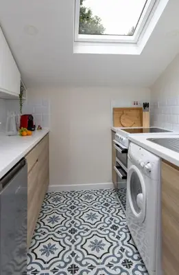 a kitchen with a washer and dryer on a tile floor at Central Cathedral Apartment in Dunblane