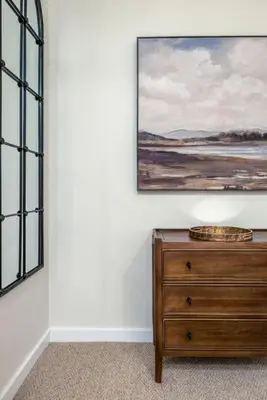 a painting hanging on a wall next to a dresser at Woodland Hideaway Near Stirling in Cambusbarron