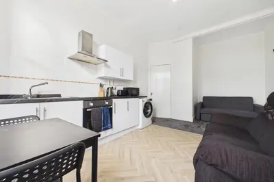a kitchen and living room with a couch and a table at West End Traditional Flat with Free Parking in Scotstoun West Station