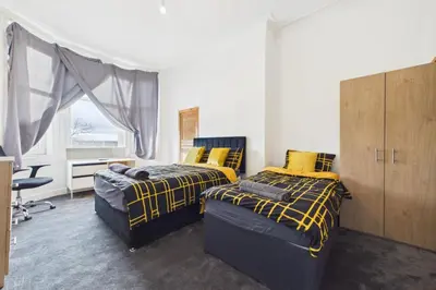 a bedroom with two beds and a desk at West End Traditional Flat with Free Parking in Scotstoun West Station