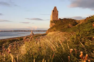 a castle on top of a hill next to the ocean at Luxury Georgian Aparthotel by Hauss Ayr - 5mins to Beach, Town Centre! in Ayr