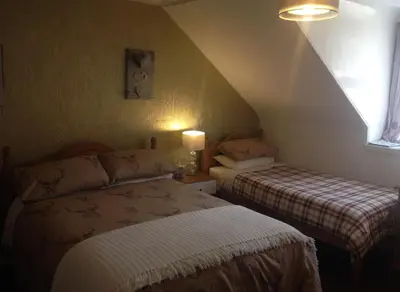 a bedroom with two beds in a attic at Tanglin Guest House in Oban