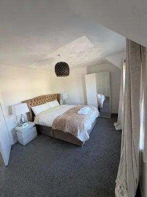 a bedroom with a large bed in a room at Chic & Cozy 2BR Semi-Detached in Kilmarnock