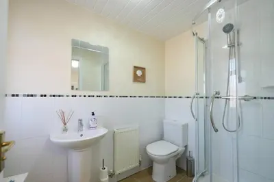 a bathroom with a toilet and a sink and a shower at Caledonia by the Sea in Saltcoats