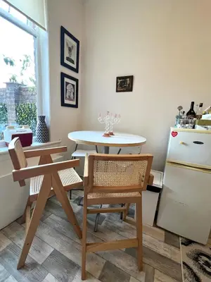 a kitchen with a table and a table and a refrigerator at Coatbridge central apartment 20 min from Glasgow in Coatbridge