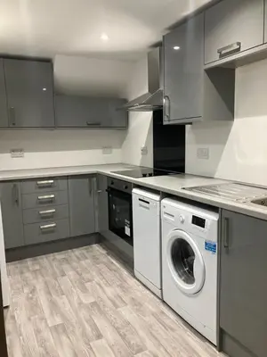 a kitchen with a washing machine and a washer at CONTRACTOR STAYS WELCOME newly refurbished 2 bedroom apartment sleeps 5 with free SECURE parking and WiFi Fully Fitted Kitchen with Washer Dryer Weekly bedding change and hoover Long Term Stay Rate available 3 miles from City Centre in Cowlairs