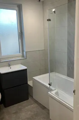 a bathroom with a tub and a sink and a shower at CONTRACTOR STAYS WELCOME newly refurbished 2 bedroom apartment sleeps 5 with free SECURE parking and WiFi Fully Fitted Kitchen with Washer Dryer Weekly bedding change and hoover Long Term Stay Rate available 3 miles from City Centre in Cowlairs