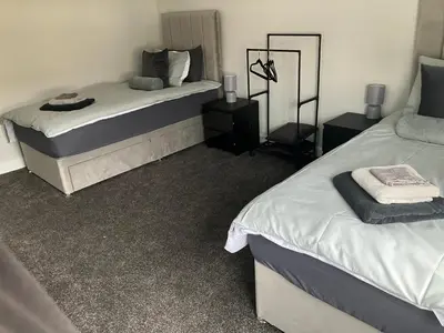 a bedroom with two beds and two night stands at CONTRACTOR STAYS WELCOME newly refurbished 2 bedroom apartment sleeps 5 with free SECURE parking and WiFi Fully Fitted Kitchen with Washer Dryer Weekly bedding change and hoover Long Term Stay Rate available 3 miles from City Centre in Cowlairs