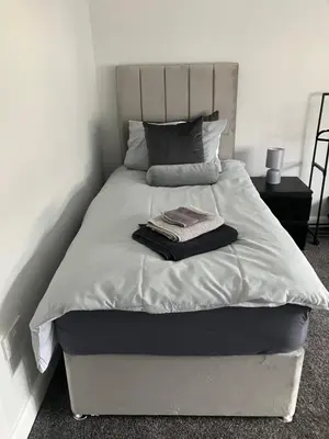 a white bed with a blanket and a towel on it at CONTRACTOR STAYS WELCOME newly refurbished 2 bedroom apartment sleeps 5 with free SECURE parking and WiFi Fully Fitted Kitchen with Washer Dryer Weekly bedding change and hoover Long Term Stay Rate available 3 miles from City Centre in Cowlairs