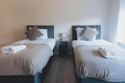 two beds sitting next to each other in a room at Stylish 3BR Home near Hampden No 264 with Free Parking in Glasgow