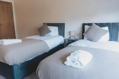 a hotel room with two beds with white sheets at Stylish 3BR Home near Hampden No 264 with Free Parking in Glasgow