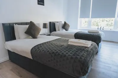 a hotel room with two beds with towels on them at Stylish 3BR Stay by Hampden No 161 with Free Parking in Glasgow