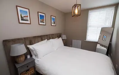 a bedroom with a white bed and a window at Stylish 3-Bed Apartment in the Heritage Quarter in Dunfermline