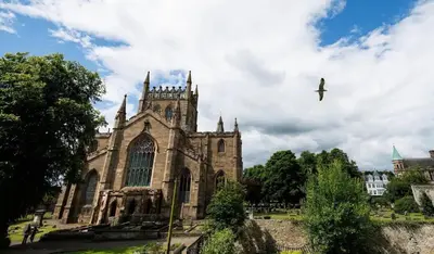 an old church with a bird flying in the sky at Stylish 3-Bed Apartment in the Heritage Quarter in Dunfermline