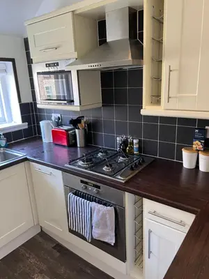 a kitchen with white cabinets and a stove top oven at Truly Central, Princes St, close to Castle in Edinburgh