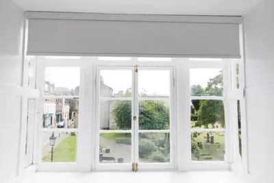 an open window with a white window shade at Stylish 2-Bed Apartment in the Heritage Quarter in Dunfermline