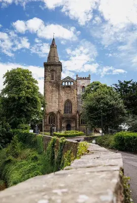 an old stone church with a tower on the side of a road at Stylish 2-Bed Apartment in the Heritage Quarter in Dunfermline