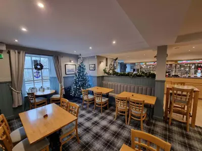 a restaurant with tables and chairs and a christmas tree at The Anchor Inn in Garelochhead