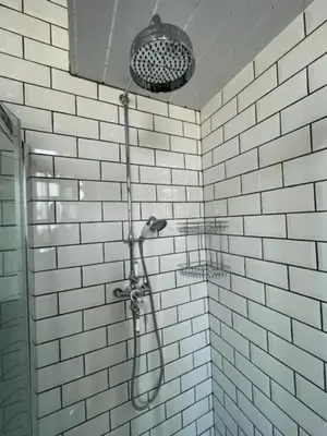 a shower in a bathroom with white tiles at Rothesay, Isle of Bute in Rothesay