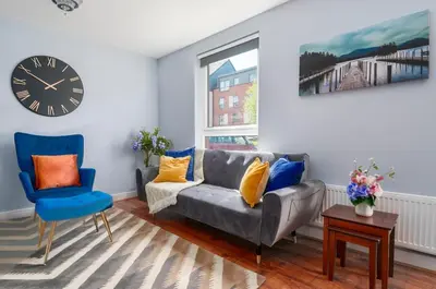 a living room with a couch and a clock at The Cozy Atmosphere Lodge in Moffat