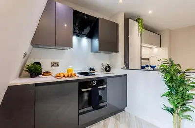 a kitchen with black and white cabinets and a stove at 121 Princess Street in Moffat