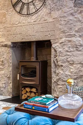 a table with books and a wood stove at Canon Cave in Edinburgh
