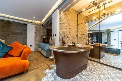 a large bathroom with a large tub and a couch at Canon Cave in Edinburgh
